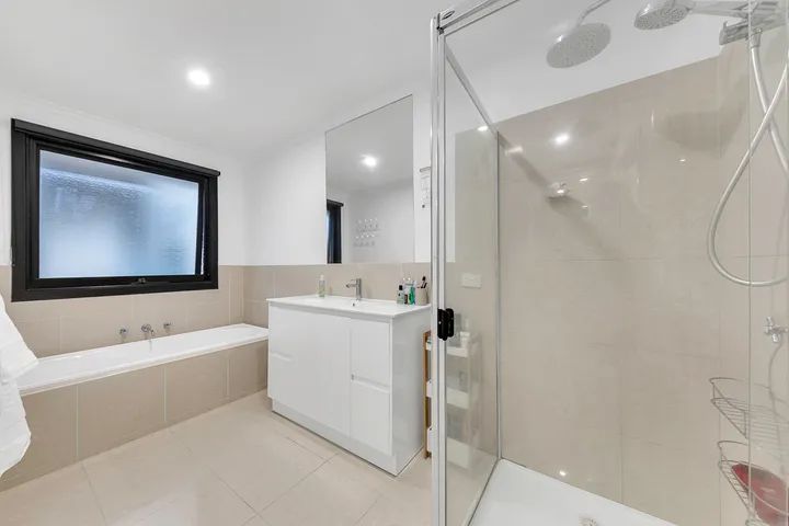 The bathroom at 3 Phelan Drive, with a bath, a separate shower, vanity and mirror.