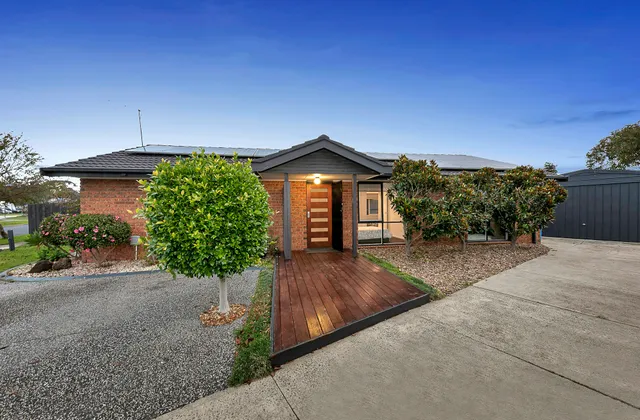 The front entrance of 3 Phelan Drive at dusk, with a lit porch, timber front door and a decked path from the driveway.